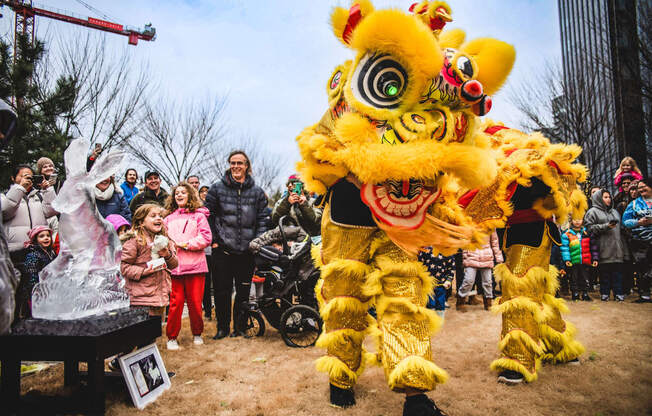 a person in a yellow lion costume standing in front of a crowd at Allied Harbor Point, Baltimore