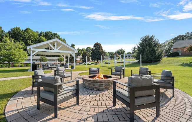 a patio with chairs and a fire pit