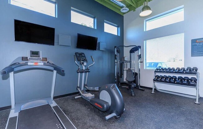 the gym is equipped with cardio equipment and televisions