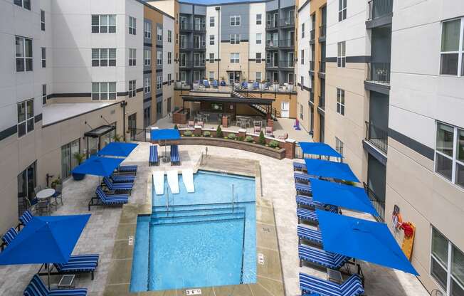 an overhead view of an apartment pool with blue umbrellas at Aster Apartments, Ohio