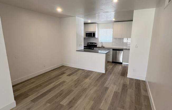 an empty living room and kitchen in an apartment