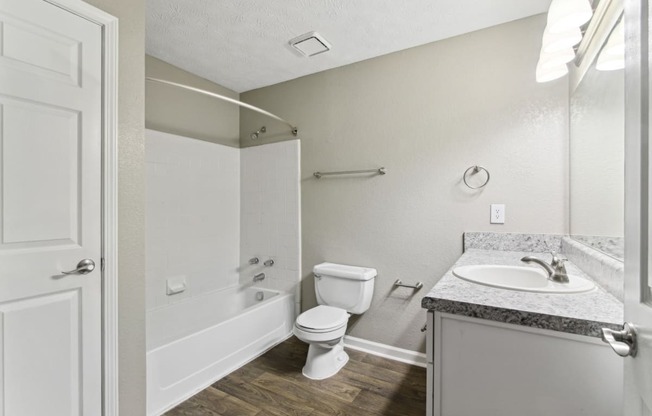 Bathroom with a toilet, sink and a bath tub at Oakley Run apartments in Smyrna, GA