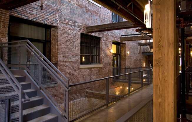 the interior of a building with stairs and a brick wall