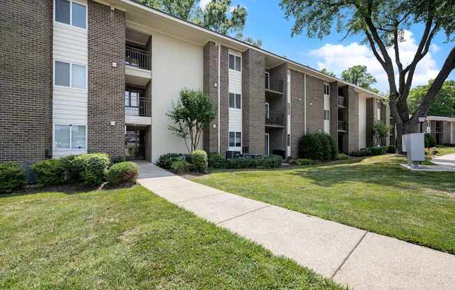 Apartment complex with a tree in front.