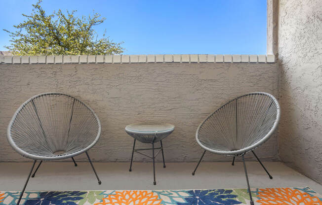 a patio with two chairs and a small table