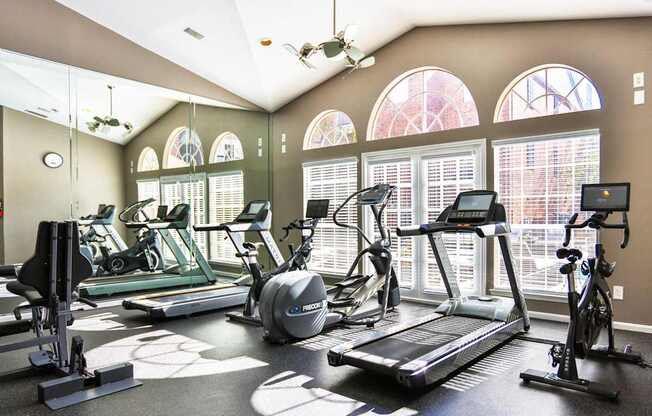 A fitness center with treadmills and elliptical machines at The Inverness Apartments in Houston, TX