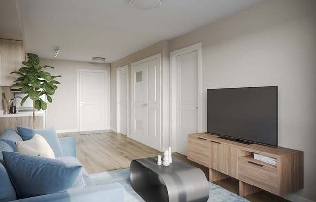 A modern living room with a blue sofa and a television on a wooden stand.