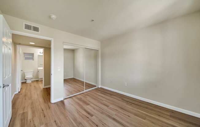 an empty living room with wood flooring and white walls