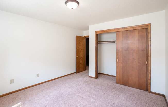 a bedroom with a closet and a door to a bathroom. Fargo, ND Hawn Apartments