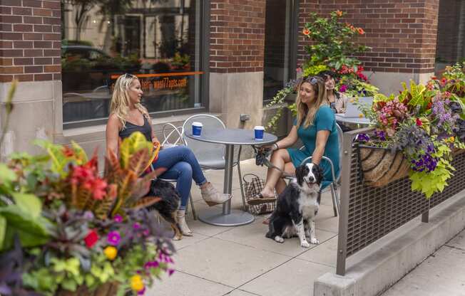 a couple of women sitting at a table with a dog
