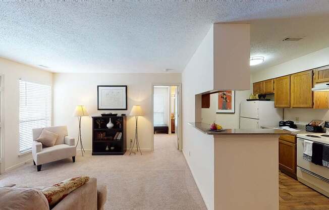 A living room with a couch, a chair, a lamp, and a picture frame on the wall.