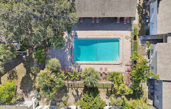 A swimming pool surrounded by trees and a building.