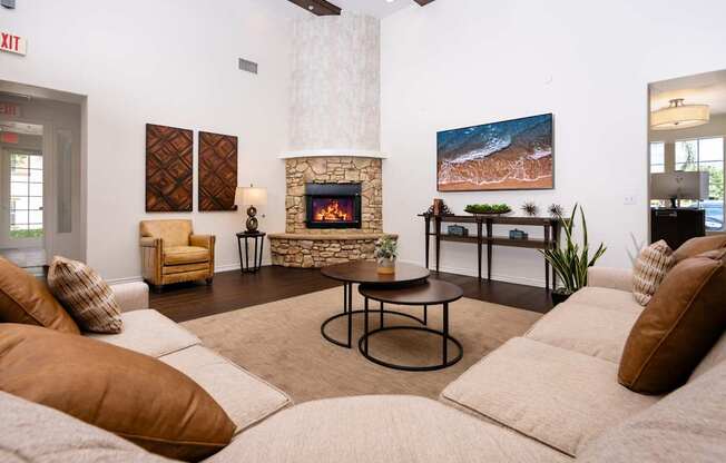 A living room with a fireplace and a painting of a beach scene on the wall.
