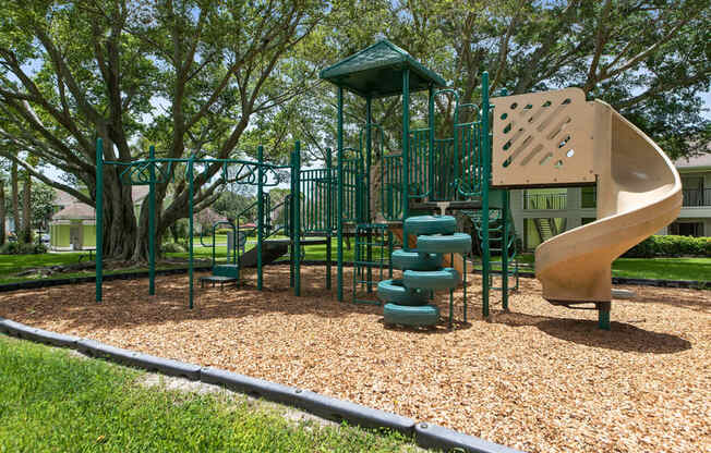 a playground with a slide and climbing equipment in a park