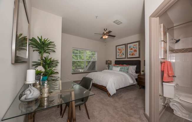 a bedroom with a bed and a glass desk