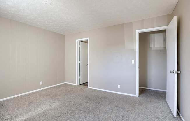 A room with carpeted floor and two doors. Omaha, NE Evergreen Terrace Apartments