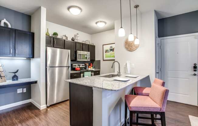 a kitchen with a island and a stainless steel refrigerator