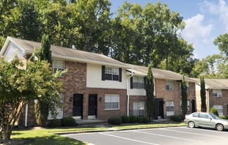 an apartment building with a parking lot and trees