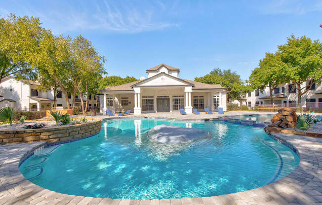 a large pool with a house in the background