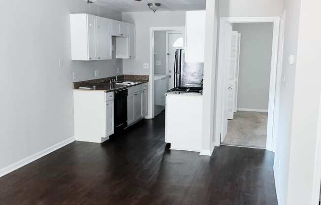 a kitchen with white cabinets and black appliances