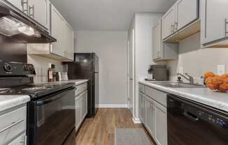 a kitchen with white cabinets and black appliances