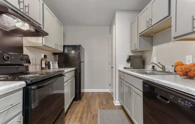 a kitchen with white cabinets and black appliances