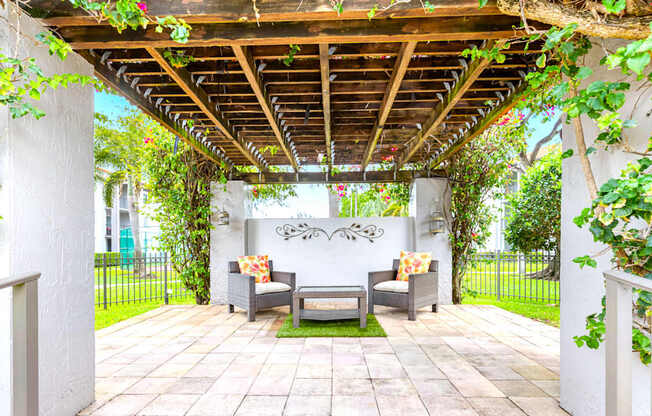 A patio with a couch and a table under a pergola.