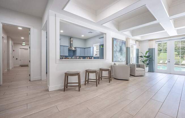 A spacious living room with a kitchen in the background and a dining table with chairs in the foregroundat Spring Creek Apartments, Crestview.