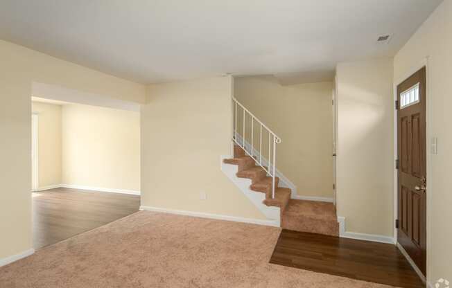 an empty living room with a staircase in a house