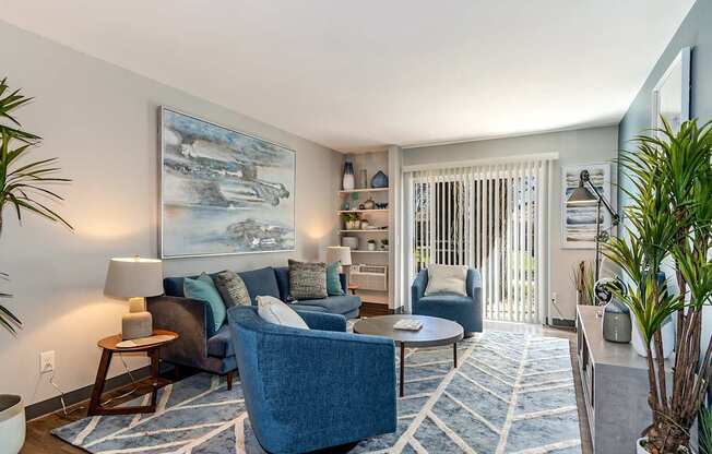 A blue couch is in the middle of a living room.