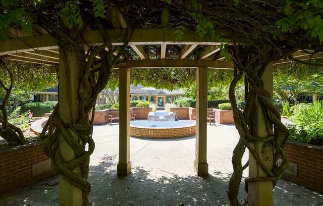a gazebo with a fountain in the middle of a courtyard