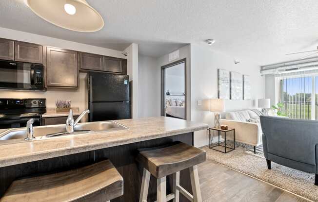 Spacious, combined kitchen and living room with breakfast bar seating.