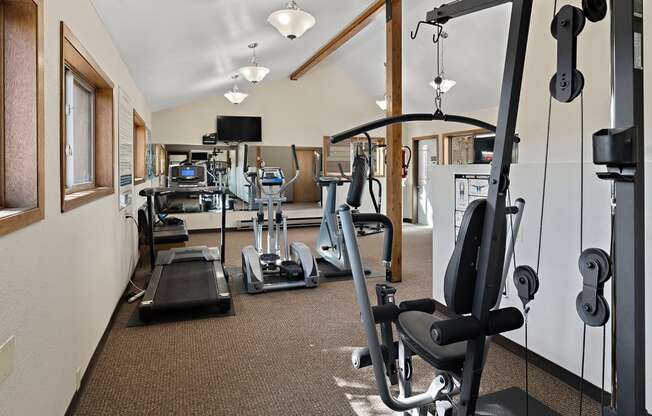 a gym with cardio machines and weights on the floor