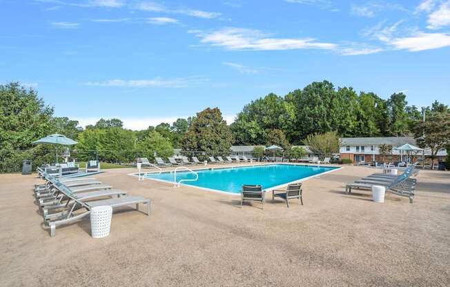 a swimming pool with chairs and umbrellas at the resort