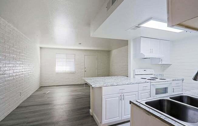 A kitchen with white cabinets and a stove top oven.