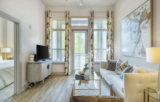 a living room with a white couch and a television