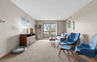 A living room with a blue chair and a grey couch.