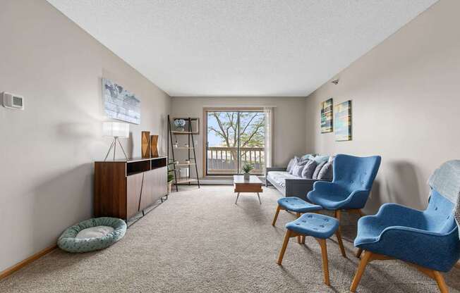 A living room with a blue chair and a grey couch.