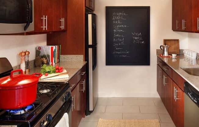 a kitchen with a pot on the stove and a blackboard on the wall