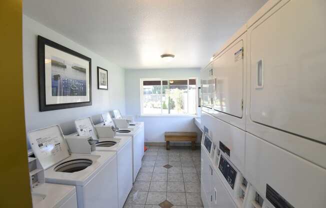 a laundry room with white appliances and a window