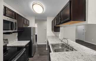 a kitchen with granite counter tops and black appliances