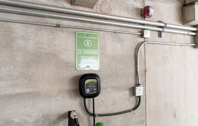 An EV charging station is installed on a concrete wall.