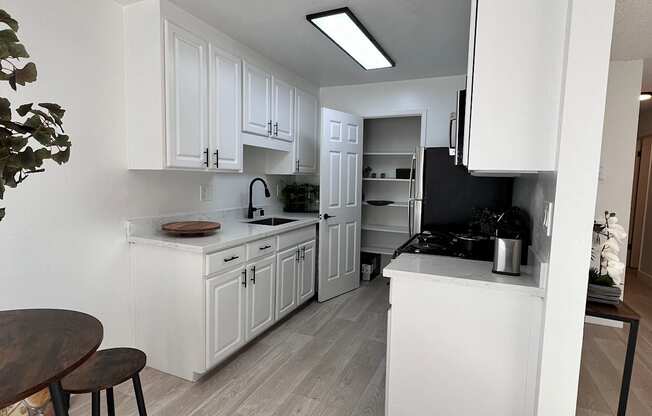 an open kitchen and dining area with white cabinets and a counter top at Campbell West Apartments, Campbell, CA 95008