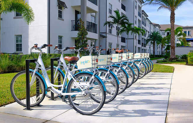 a row of bikes parked in front of an apartment building