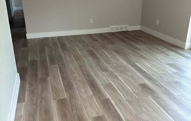 A room with a wood floor and a white wall.