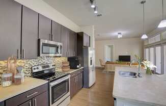 a large kitchen with stainless steel appliances and marble counter tops