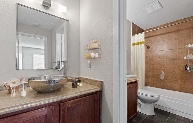 A bathroom with a brown counter top and a white toilet.