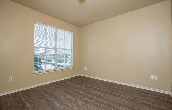 a room with wood floors and a large window