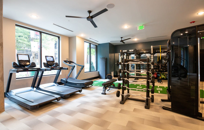 a gym with cardio machines and weights on a checkered floor