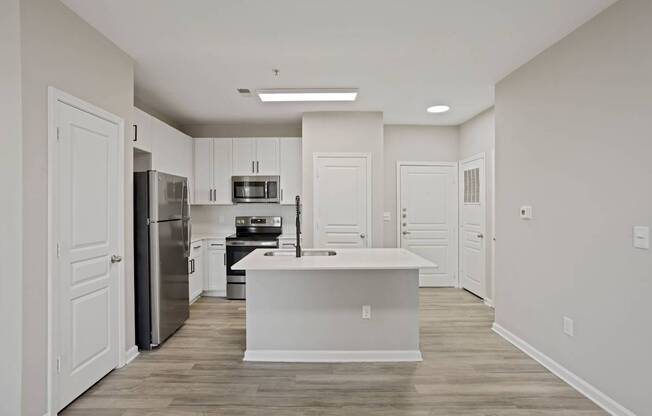 Flatiron West Trade Apartments unstaged model unit with quartz countertops, island, stainless steel appliances and a large living room.